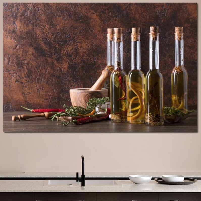 tablou canvas cu sticle de ulei pe o masa cu diverse mirodenii si verdeturi, intr-un cadru rustic de bucatarie