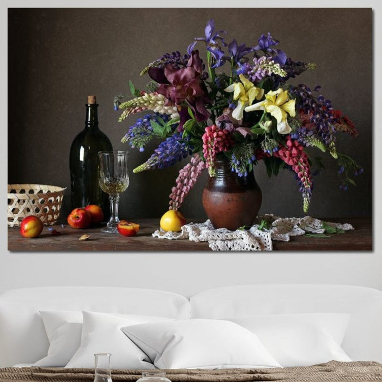 tablou canvas cu o vaza cu flori colorate, pe o masa cu o sticla de vin, un pahar si fructe, intr-un cadru rustic