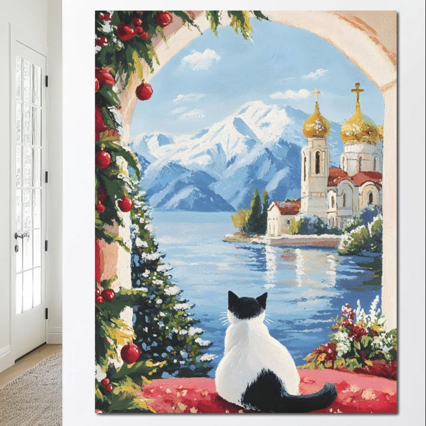 tablou canvas cu o pisica in alb si negru, inconjurata de ornamente de Craciun, privind catre o Biserica dincolo de apa, pe fundal montan