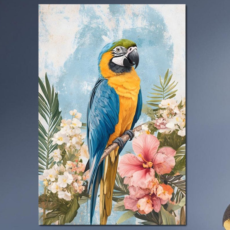 tablou canvas cu un papagal exotic albastru si galben, pe o creanga, inconjurat de frunze si flori tropicale