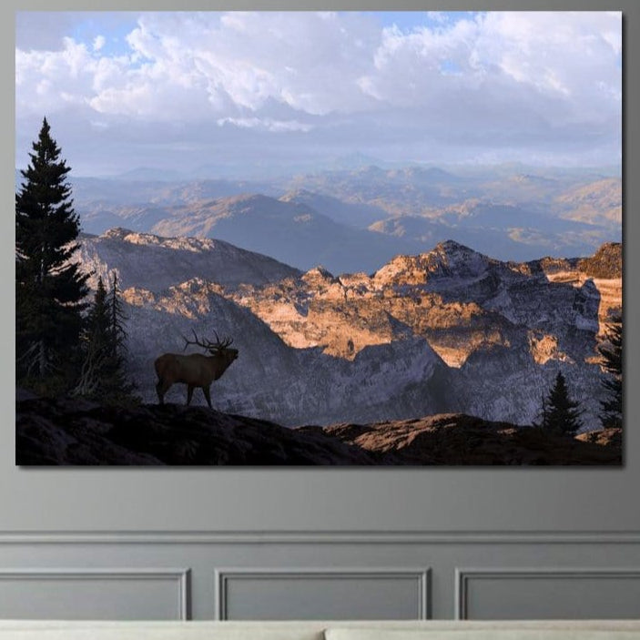 tablou canvas cu un elan intr-un peisaj montan, inconjurat de copaci si stanci sub cer senin