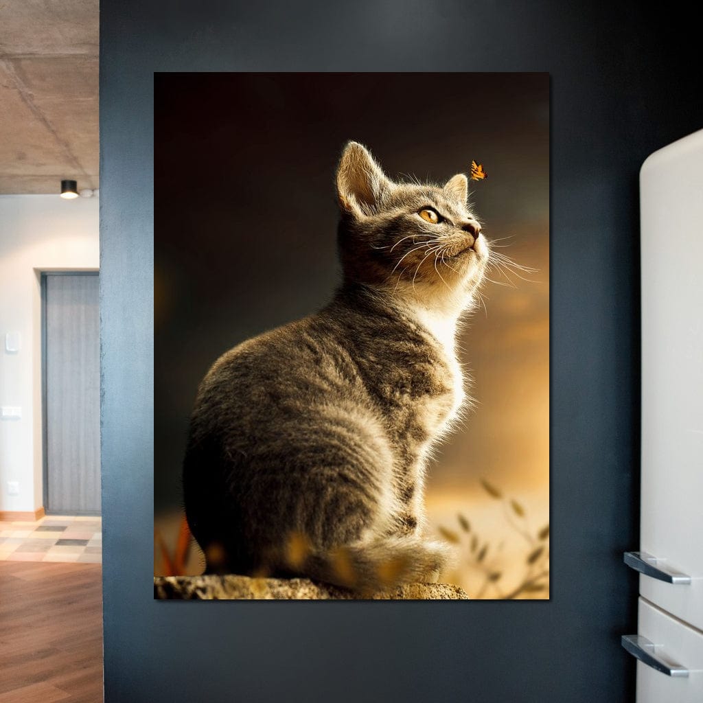 tablou canvas cu o pisica mica privind un fluture, pe fundal natural in lumina calda de apus