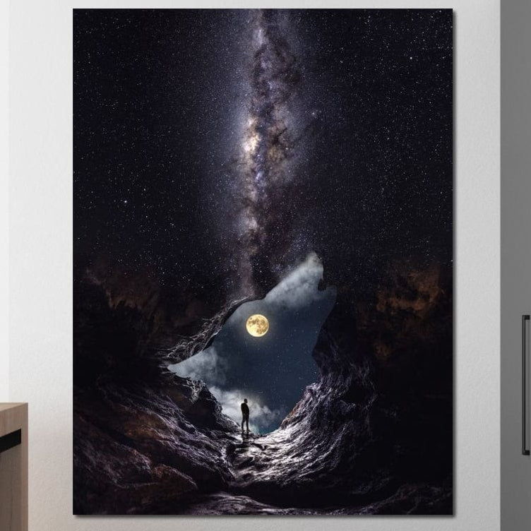 O persoană stă la marginea unei peșteri, admirând luna plină și Calea Lactee într-o scenă mistică, surprinsă în Tablou Canvas Premium LuxCanva® M1468 - Glasul Universului, decor ideal pentru birou sau camera copilului.