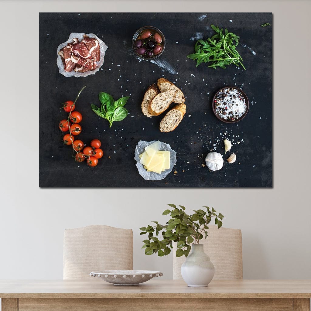 tablou canvas cu bruschette, rosii cherry, verdeturi, condimente si prosciutto pe o masa neagra