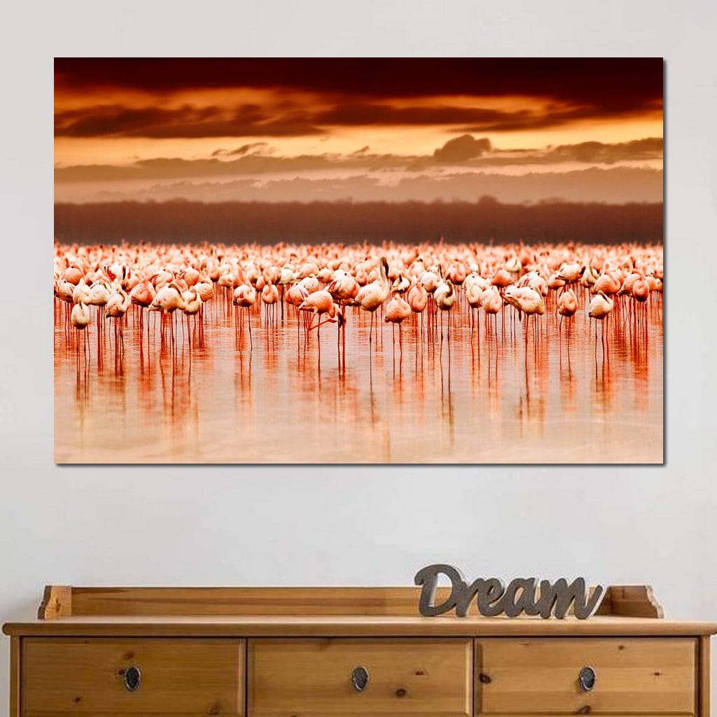 tablou canvas cu un stol de flamingo roz pe apa, sub cer cu apus indian