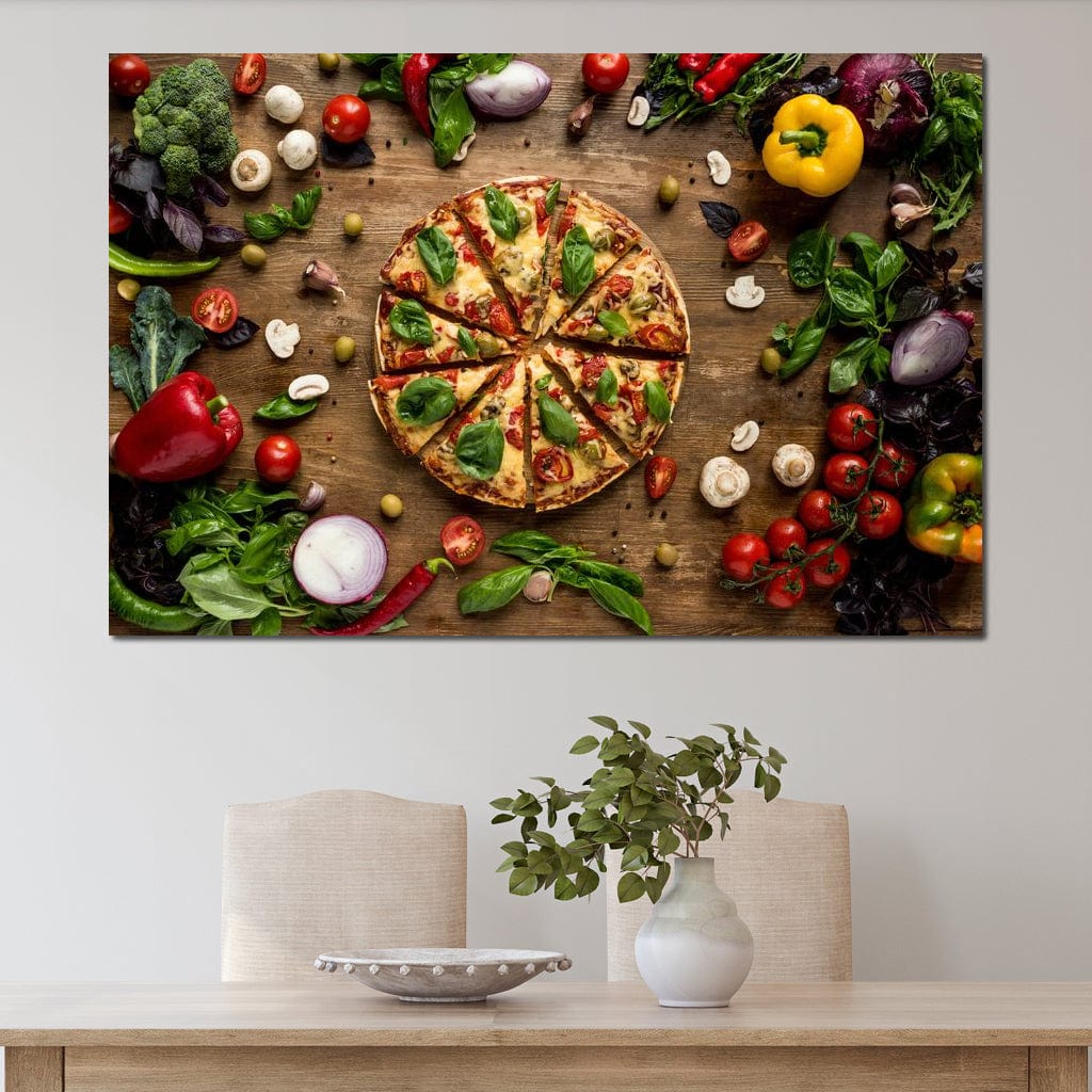 tablou canvas cu o pizza taiata in felii, pe o masa de lemn inconjurata de legume si condimente