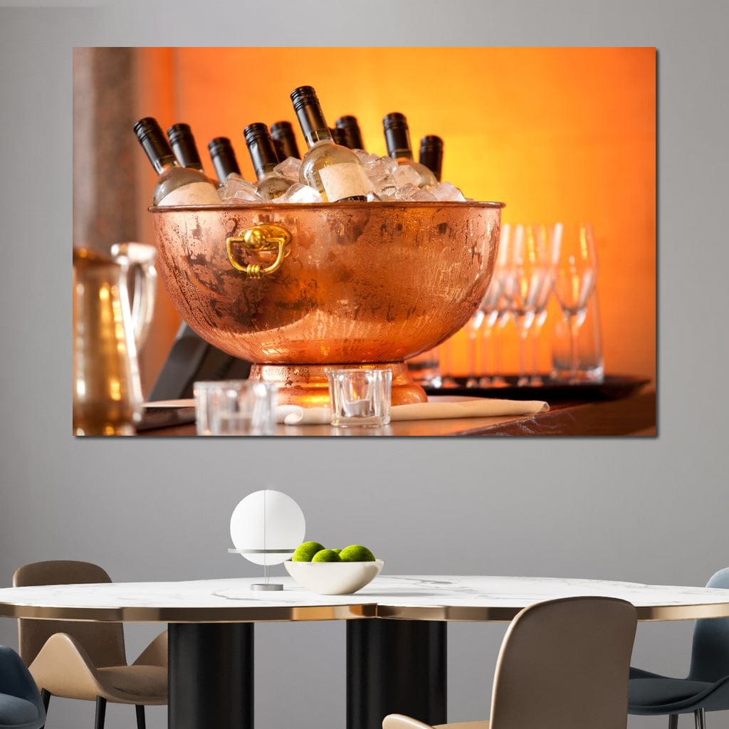 tablou canvas cu o frapiera transparenta cu sticle de vin alb si gheata, pe fundal portocaliu cu pahare si lumina calda