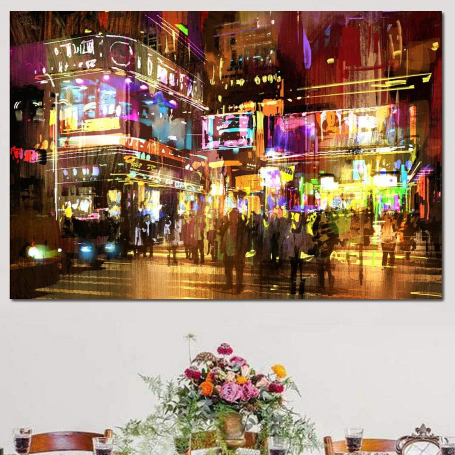 Tabloul LuxCanva® Tablou Canvas Premium "Nopti Electrice" (O1023) prezintă o stradă de oraș explozivă, colorată, pe timp de noapte, cu lumini de neon și mulțimi pline de viață, perfectă deasupra unei mese cu o vază de flori asortate.