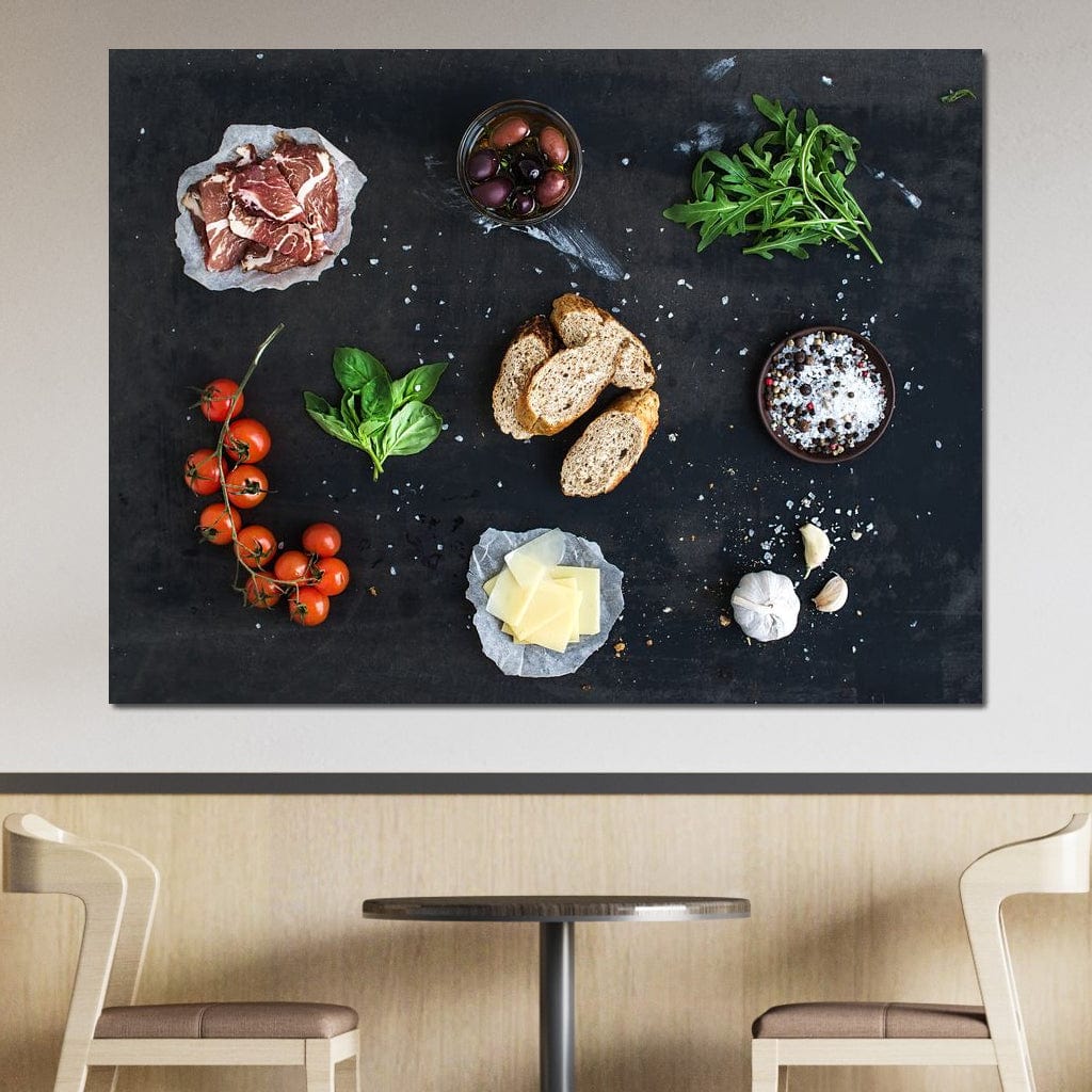 tablou canvas cu bruschette, rosii cherry, verdeturi, condimente si prosciutto pe o masa neagra