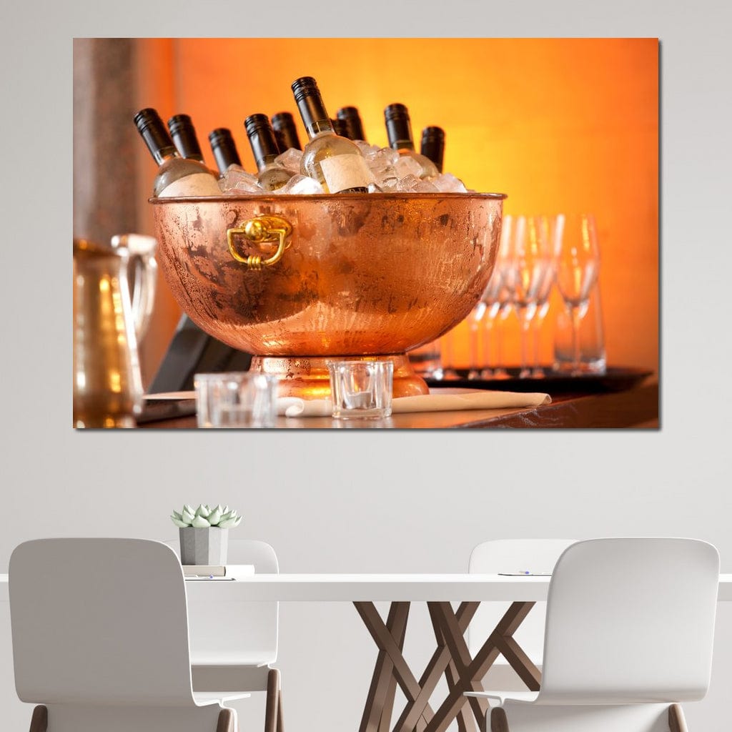 tablou canvas cu o frapiera transparenta cu sticle de vin alb si gheata, pe fundal portocaliu cu pahare si lumina calda