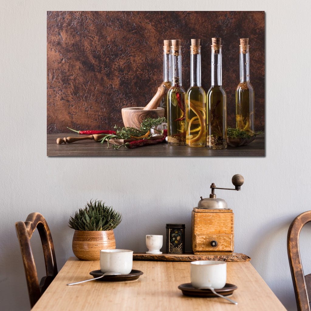 tablou canvas cu sticle de ulei pe o masa cu diverse mirodenii si verdeturi, intr-un cadru rustic de bucatarie