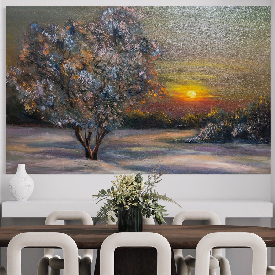 O sală de mese cu o masă din lemn închis la culoare, scaune deschise la culoare și verdeață într-o vază are pe perete Tablou Canvas Premium B1131 "Copacul Magic" de la LuxCanva® - un peisaj vibrant de apus de soare cu copaci și ceruri colorate.