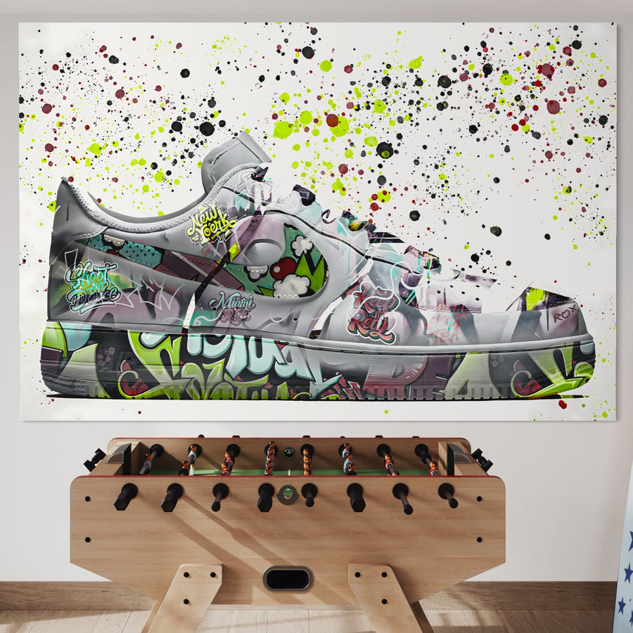 Un foosball este așezat în fața unui perete decorat cu Tablou Canvas Premium LuxCanva® B1076, ilustrând un sneaker Air Force 1 Nike colorat, perfect pentru un decor vibrant și de calitate în camera copiilor sau dormitor.