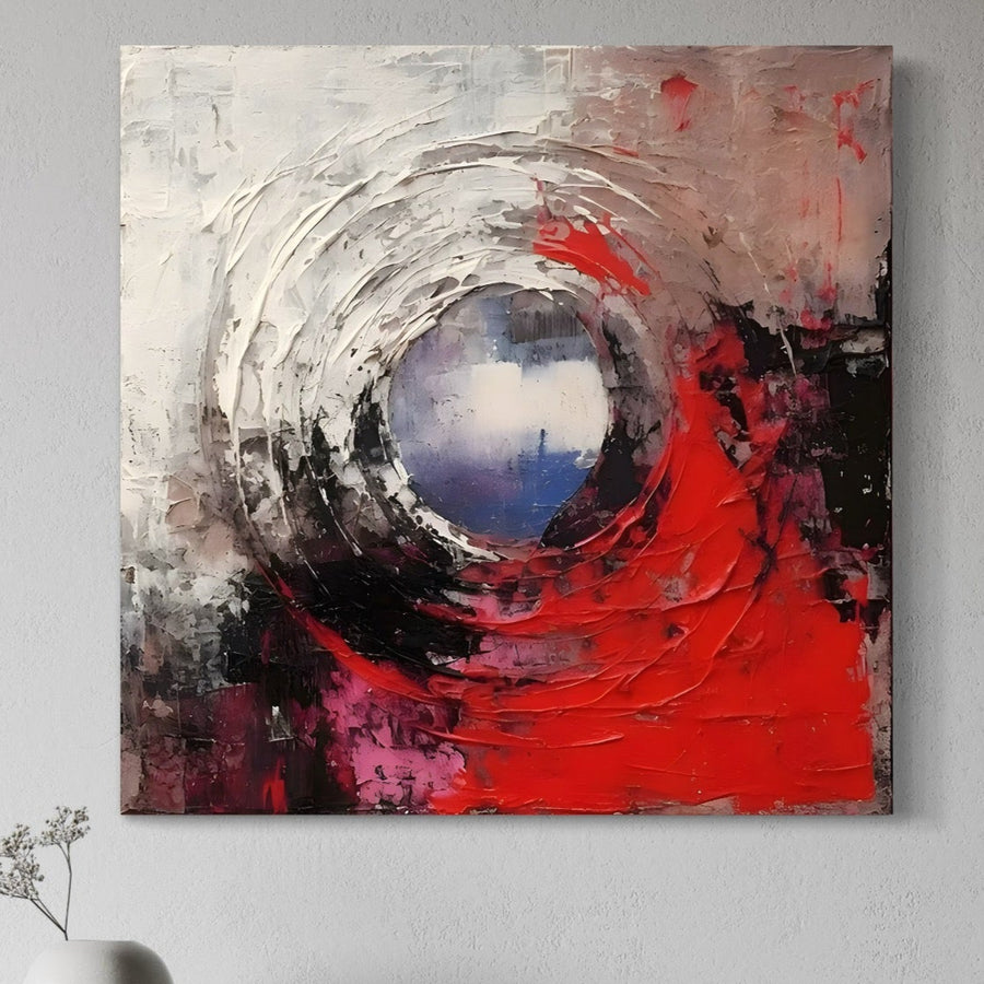 Tablou Canvas Premium LuxCanva® A1647, Atomul prezintă un design circular abstract cu tușe vibrante de roșu, roz și negru. Acest print decorativ pe pânză de la LuxCanva® este ideal pentru dormitoare sau camere de zi și arată uimitor deasupra unei vaze albe.