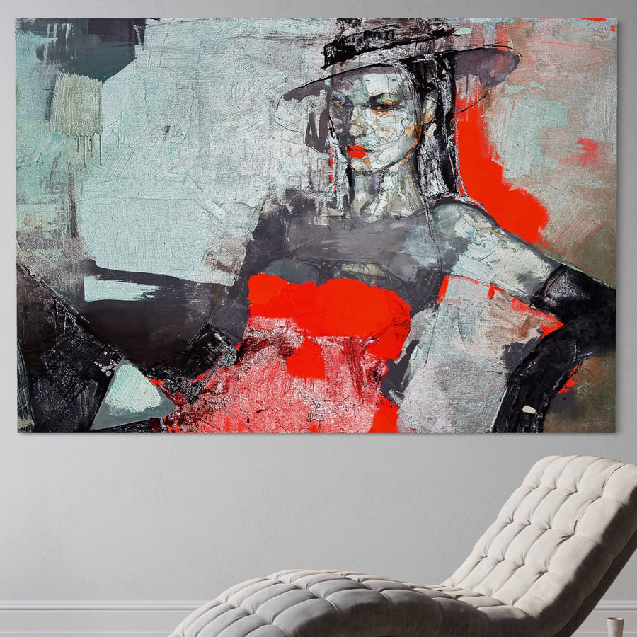 Tablou Canvas Premium LuxCanva® A1262, Lady In Red, portret stilizat cu femeie în pălărie, culori vibrante roșu și negru pe pânză bumbac premium, montat pe perete gri deschis deasupra unui fotoliu alb modern.