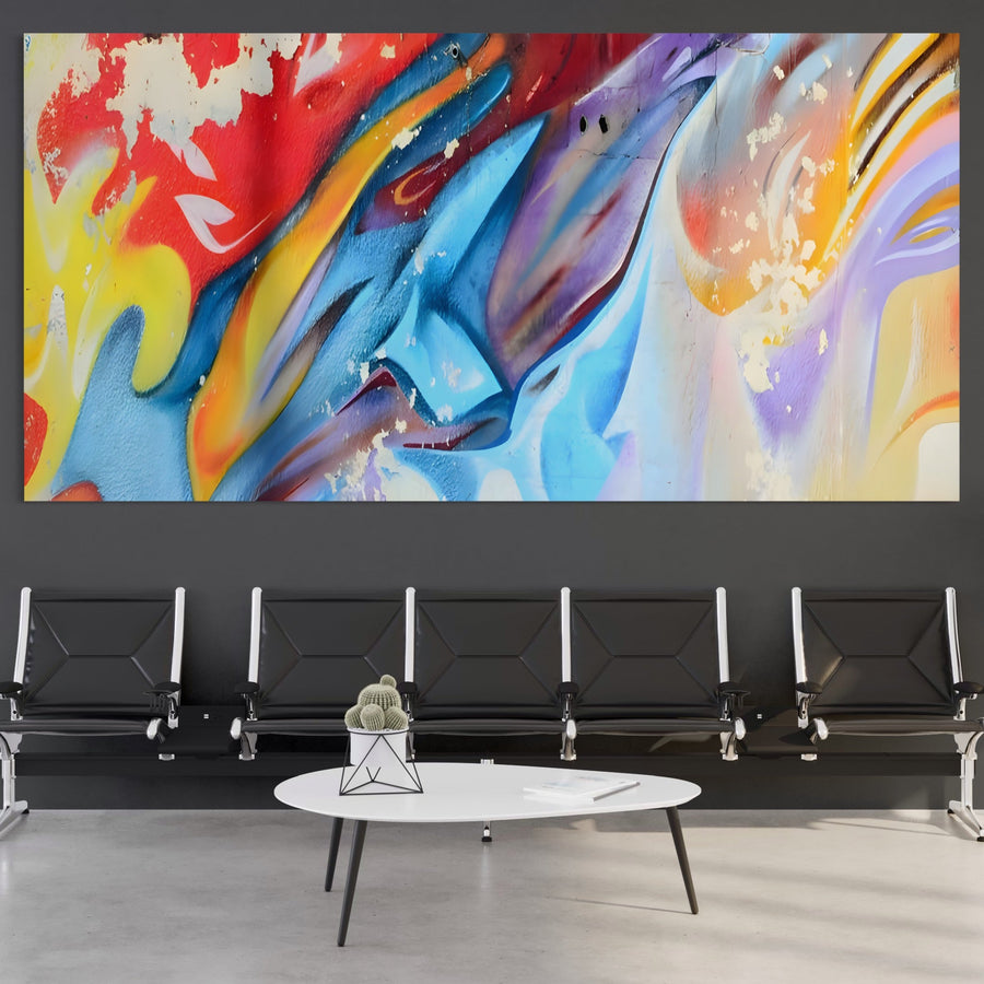 O zonă de așteptare modernă, cu scaune negre, o măsuță de cafea albă și o mare pictură murală abstractă vibrantă pe perete: Tablou Canvas Premium LuxCanva® A1223, multicolor, decorativ cu culori vibrante de la LuxCanva®.