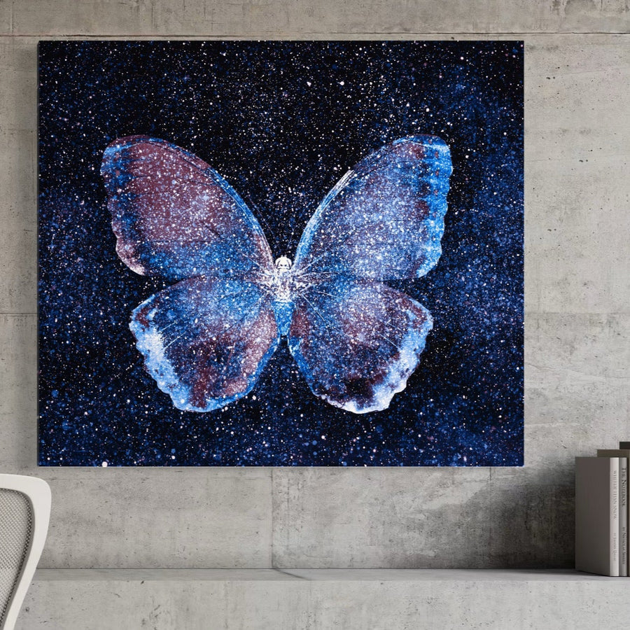 Tablou Canvas Premium LuxCanva® C1099, cu un fluture strălucitor în nuanțe albastre și mov, cu detalii galaxie, este imprimat pe bumbac de calitate premium și expus pe perete, perfect pentru living sau birou.
