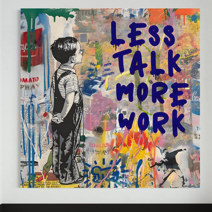 Tablou Canvas Premium A1200 de la LuxCanva® prezintă o imprimare vibrantă, în stil graffiti, a unui băiat în salopetă care privește "LESS TALK MORE WORK", stratificat cu vopsea colorată și ziare - un decor motivațional ideal pentru birou sau spații de locuit.