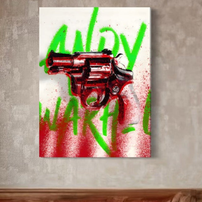 Tabloul LuxCanva® Tablou Canvas Premium C1115, "Bloody Gun By Andy Warhol", prezintă un revolver roșu cu "ANDY WARHOL" pictat cu spray în verde îndrăzneț pe un fundal alb, cu accente roșii - perfect pentru baruri sau săli de jocuri.