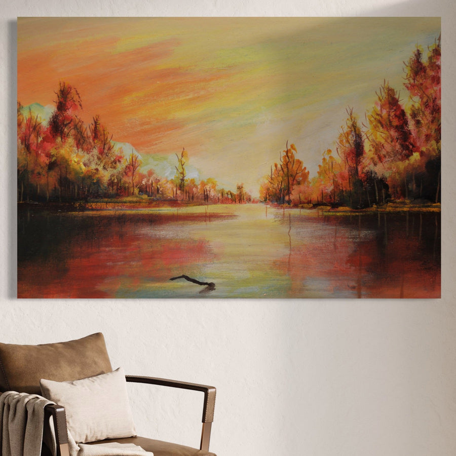 Tabloul LuxCanva® Tablou Canvas Premium LuxCanva® A1102, "Apus De Toamna", prezintă o scenă vibrantă de toamnă cu lac și pădure la apus, expusă pe un perete luminos deasupra unui scaun cu pernă, cu o pătură pliată pe braț.