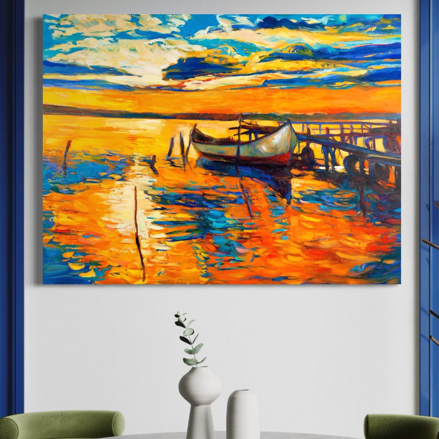 Tablou Canvas Premium LuxCanva® A1064, cu o barcă abstractă vibrantă la apus pe mare, ponton și tonuri portocalii, de LuxCanva®, decorează un perete alb deasupra unei mese minimaliste cu vaze și o plantă.