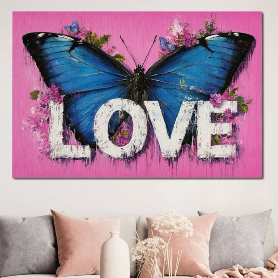 Tabloul LuxCanva® Tablou Canvas Premium E1015 "Metamorfoza Sentimentelor" prezintă un fluture albastru îndrăzneț și flori roz, cu "Iubire" pe o pânză vibrantă - perfect deasupra unei canapele cu perne pastelate pentru un accent viu în camera de zi.