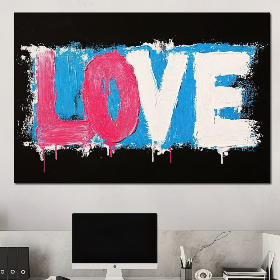 Un birou modern cu un computer și accesorii, evidențiat de un tablou Canvas Premium E1016 LuxCanva® deasupra biroului - "LOVE" cu litere îndrăznețe pe albastru și negru vibrante, adăugând contrast elegant și culoare premium spațiului.