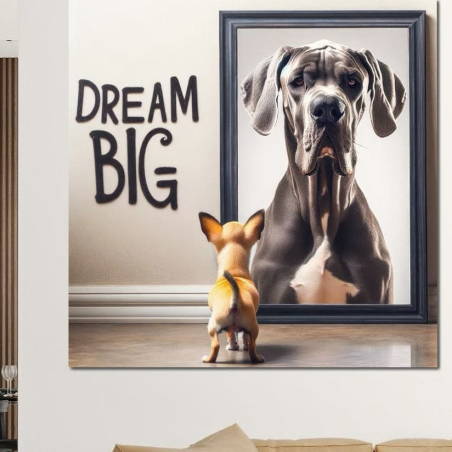 Un câine mic stă în fața unei oglinzi, reflectând un câine mare, alături de textul îndrăzneț "DREAM BIG". Tabloul LuxCanva® Tablou Canvas Premium F1001 "Puterea Viselor" inspiră ambiție și este perfect pentru camera dvs. de zi cu culorile sale vibrante.