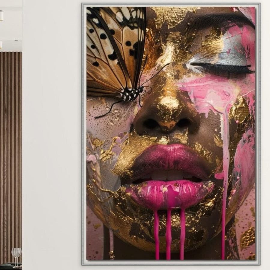 Tablou Canvas Premium LuxCanva® G1030, Efectul Fluturelui, prezintă un chip de femeie cu vopsea aurie și roz, buze picurate în roz și un fluture deasupra unui ochi - o piesă de expresionism elegantă de la LuxCanva®, perfectă pentru camera de zi sau dormitor.
