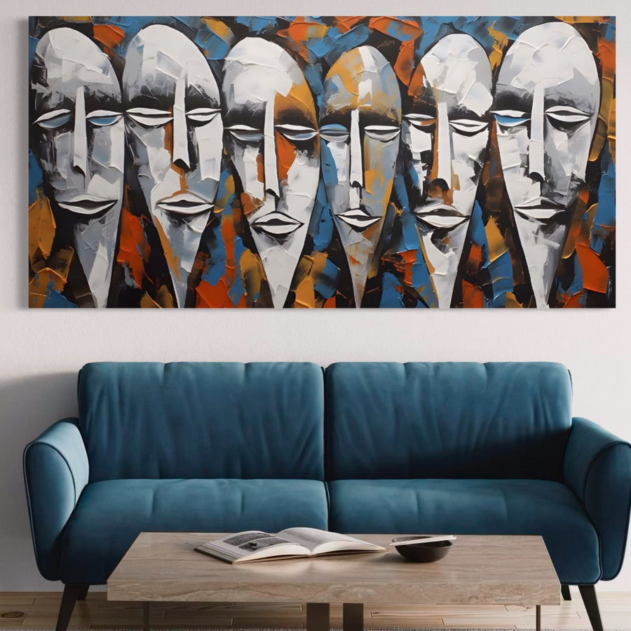 O cameră de zi are o canapea albastră și o măsuță de cafea din lemn cu o carte deschisă și un bol. Deasupra canapelei atârnă Tablou Canvas Premium LuxCanva® A1381, "Masti" - o operă de artă modernă abstractă cu culori vibrante și fețe stilizate.