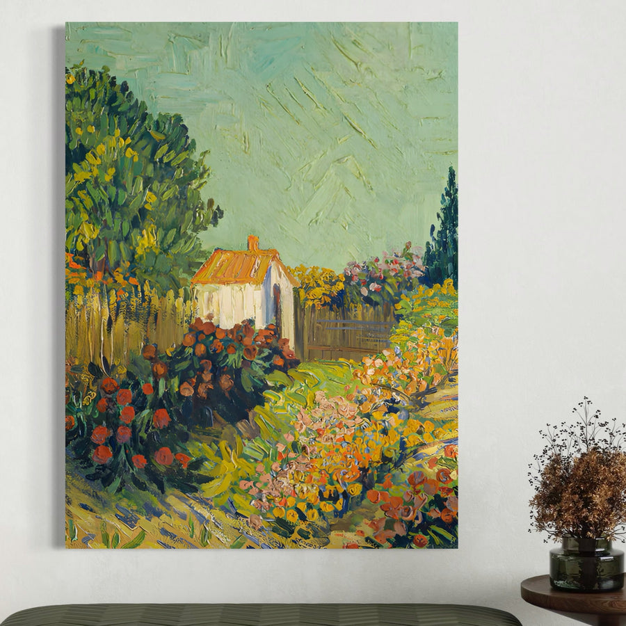 Tablou Canvas Premium LuxCanva® A1411 ilustrează o casă albă cu acoperiș roșu, înconjurată de flori și copaci colorați, decorând un perete alb. Un aranjament floral uscat pe masa completă farmecul acestui tablou LuxCanva®.