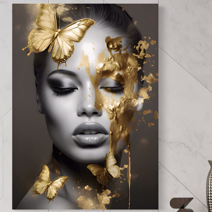Tablou Canvas Premium LuxCanva® A1465 "Vraja Fluturilor": portret în tonuri de gri al unei femei cu ochii închiși, accentuat cu stropi aurii și trei fluturi aurii, contrastând elegant monocromul cu accentele metalice.