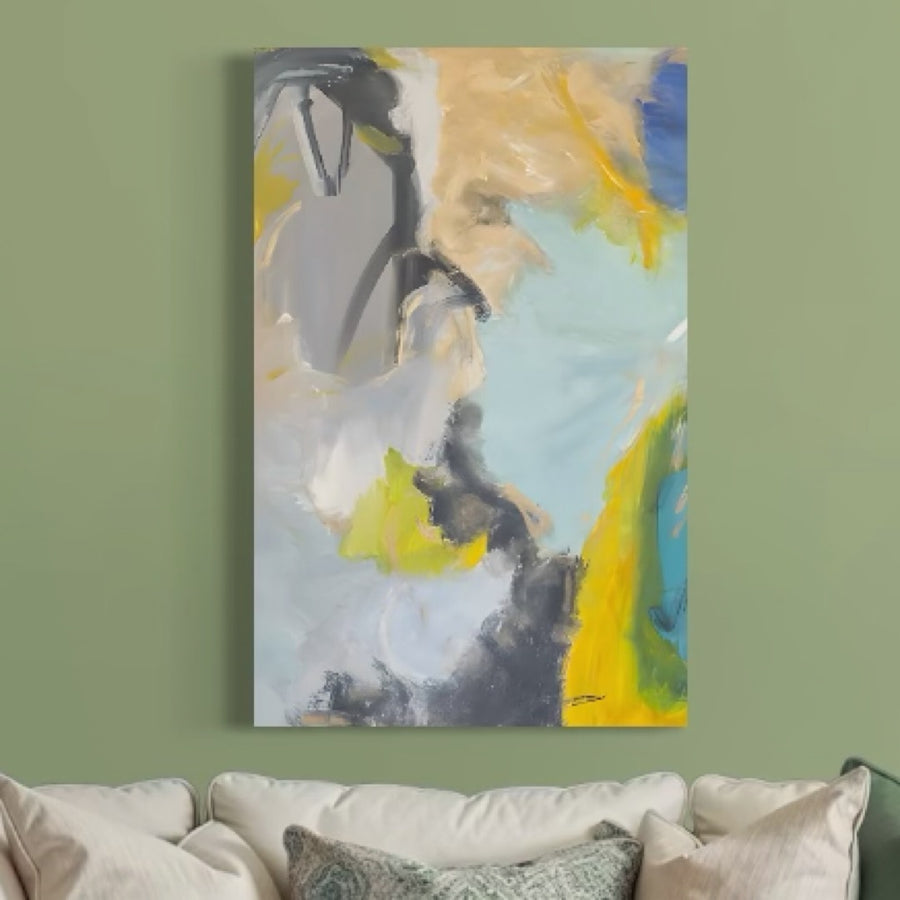 Tablou Canvas Premium LuxCanva® C1241 "Calatorie In Spatiu" cu swirls albastre, galbene, gri, albe și accente verzi decorează peretele verde pal deasupra unei canapele bej cu perne albe și verzi.