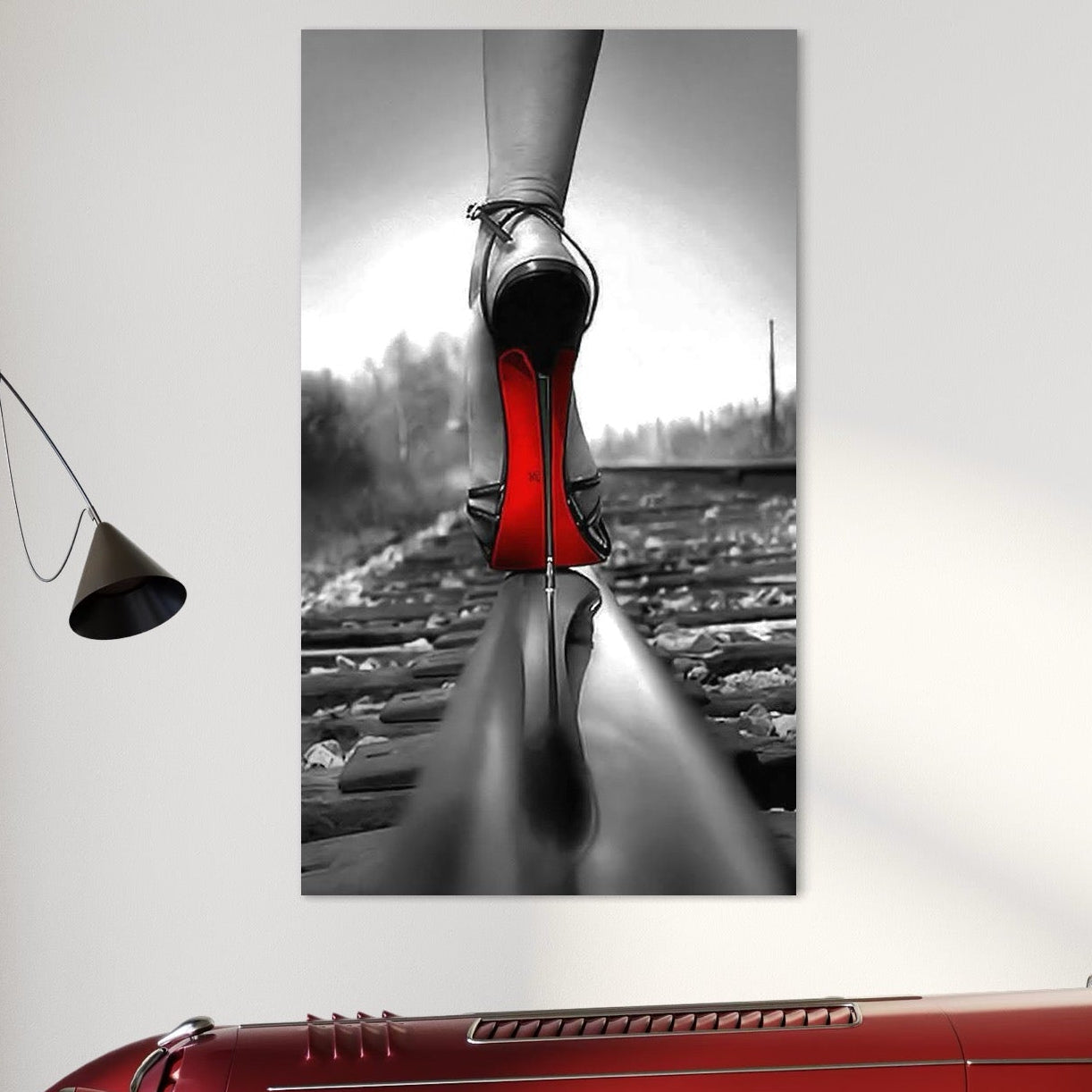 tablou canvas cu un pantof cu toc subtire si talpa rosie, pe o sina de tren, intr-un cadru provocator alb si negru