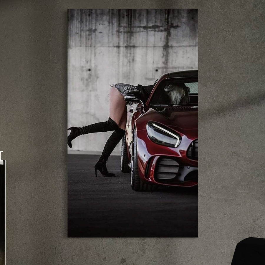 tablou canvas cu o femeie cu cizme cu toc, surprinsa intr-o masina rosie intr-o ipostaza sexy, pe fundal in stil urban