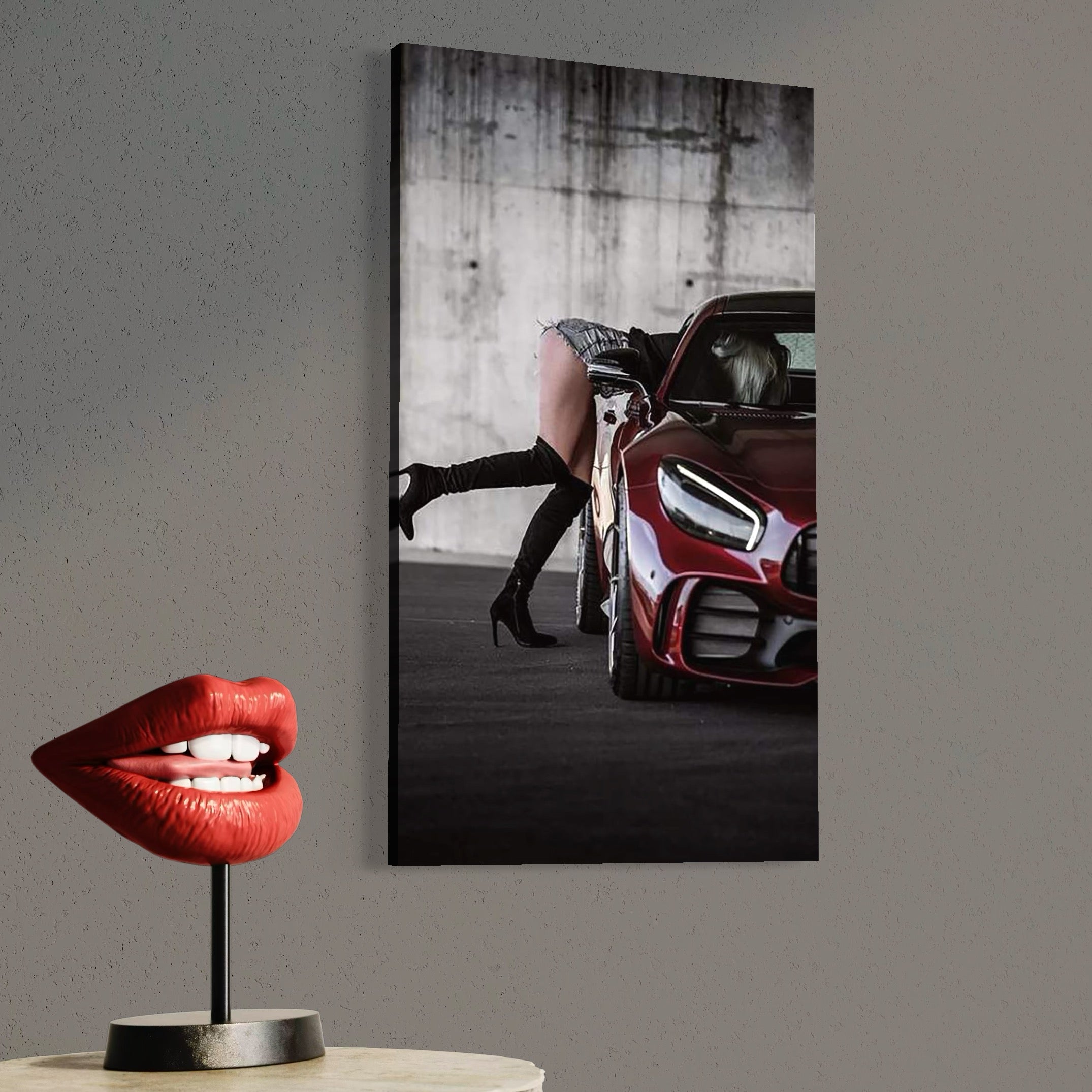 tablou canvas cu o femeie cu cizme cu toc, surprinsa intr-o masina rosie intr-o ipostaza sexy, pe fundal in stil urban