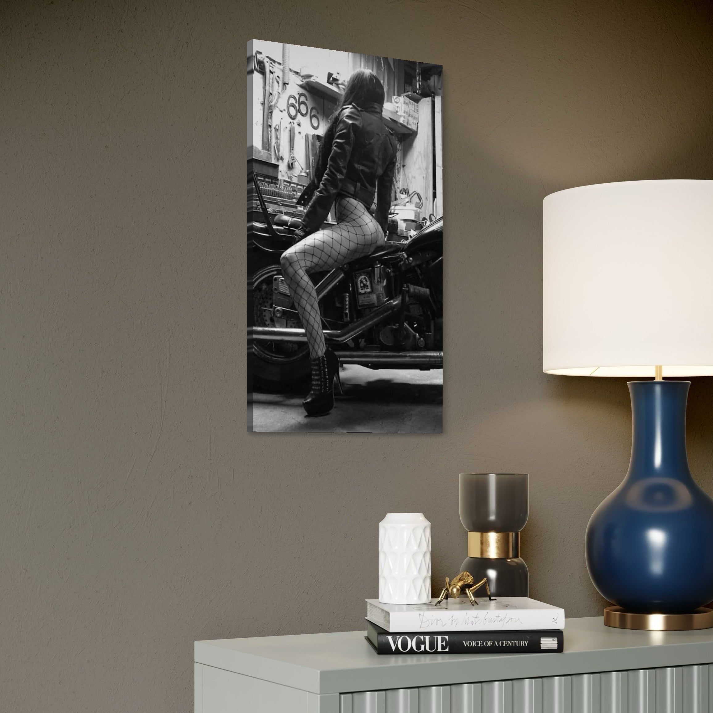 tablou canvas cu o femeie cu dresuri tip plasa pe o motocicleta , intr-un garaj redat in nuante de alb si negru