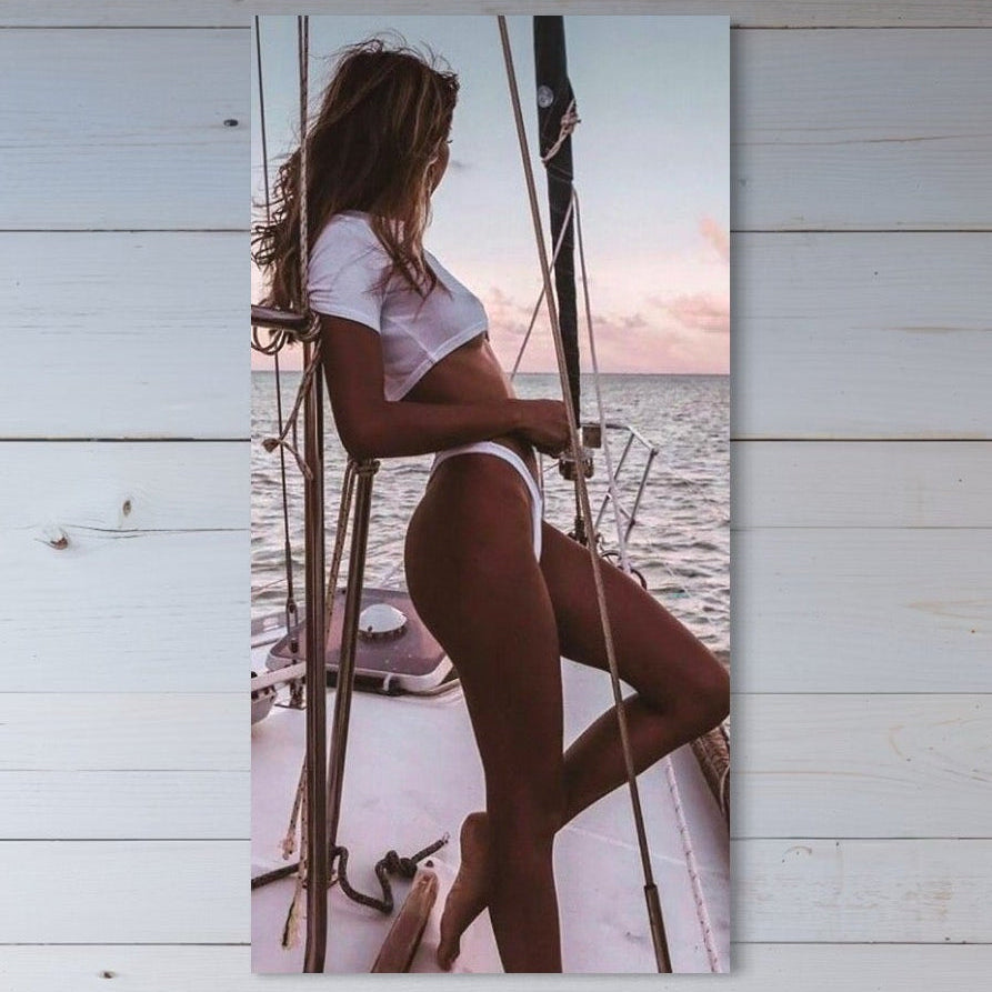 O femeie sexy în crop top alb și bikini admiră oceanul la apus, pe o corabie. Descoperă Tablou Canvas Premium, LuxCanva® P1066 - Tentatia Marii, perfect pentru dormitor sau living. Brand: LuxCanva® - Magazin tablouri canvas premium.