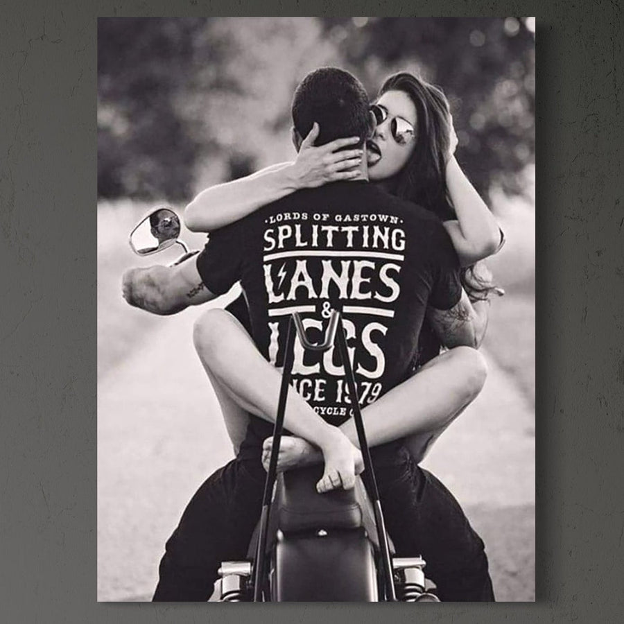 tablou canvas cu o femeie cu ochelari de soare si un barbat imbratisati pe o motocicleta, intr-un cadru  retro alb si negru