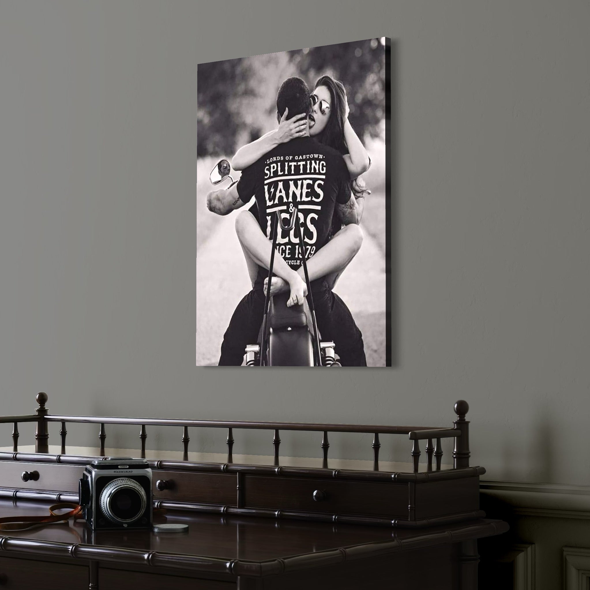 tablou canvas cu o femeie cu ochelari de soare si un barbat imbratisati pe o motocicleta, intr-un cadru  retro alb si negru