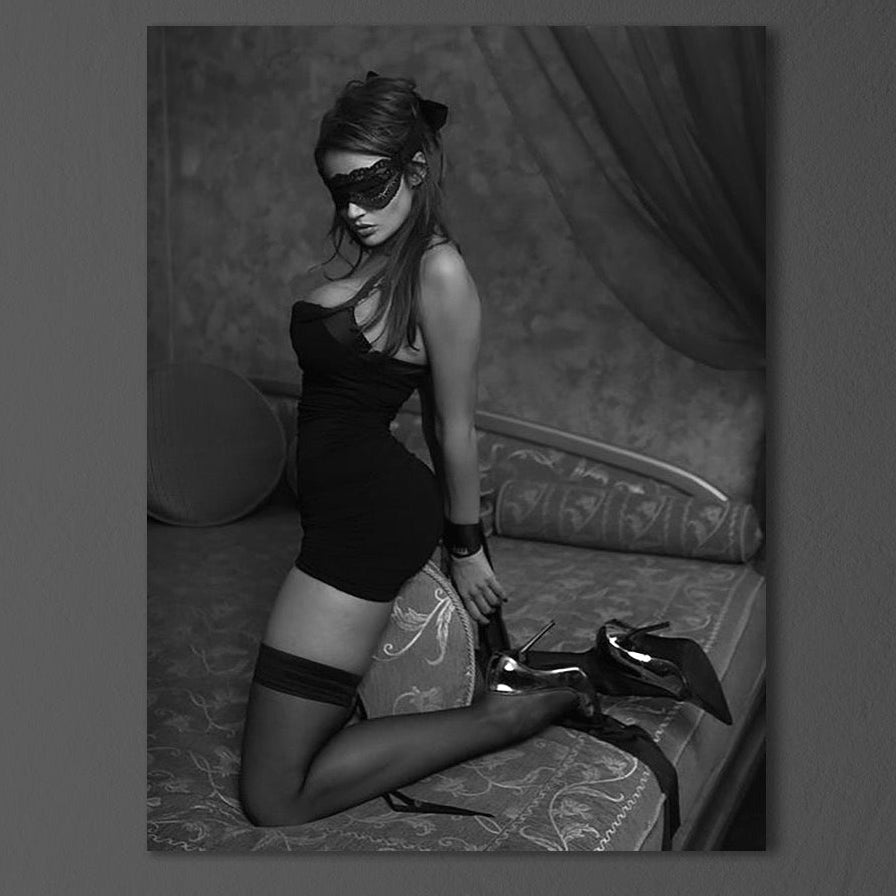 Tabloul canvas premium LuxCanva® P1070 "Prizoniera Noptii" prezintă o femeie seducătoare, în alb-negru, cu mască și tocuri, ideal pentru dormitor sau living. Afișat pe perete întunecat deasupra unei suprafețe de marmură.