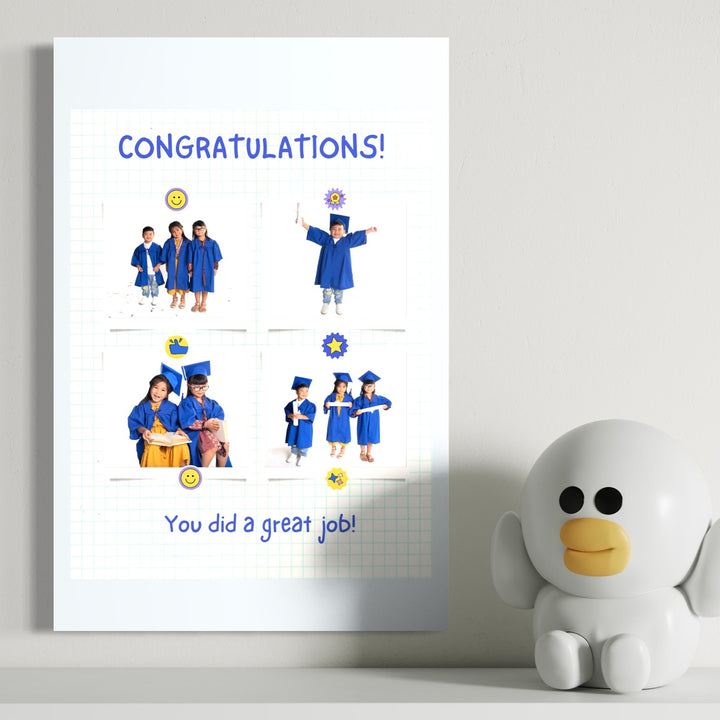 O felicitare pe perete spune "Felicitări!" cu copii în rochii de absolvire albastre lângă o figurină de pinguin - inspirație pentru Tablou Canvas Personalizat cu 4 Poze Pentru Absolvire "Congratulations", PS191 de la LuxCanva®.