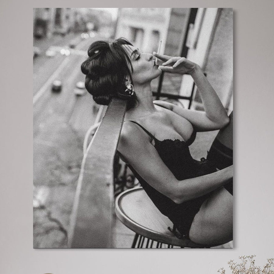 Tablou Canvas Premium LuxCanva® P1000, "Femeia de pe balcon" - fotografie alb-negru cu o femeie senzuală, fumând pe balcon și privind orașul urban. Ideal pentru living sau dormitor, adaugă eleganță și intimitate spațiului tău.