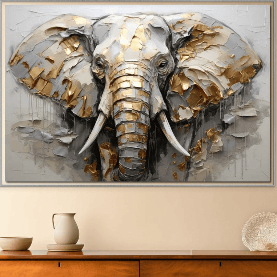 A LuxCanva® Tablou Canvas Premium, Simbol Ancestral Elefant, cu accente aurii și argintii texturate, este expus deasupra unei comode din lemn decorate minimalist cu vaze ceramice și un bol împletit.