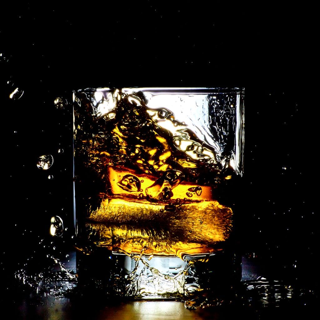 tablou canvas cu un pahar de whisky, redat in mod dramatic intr-un cadru intunecat