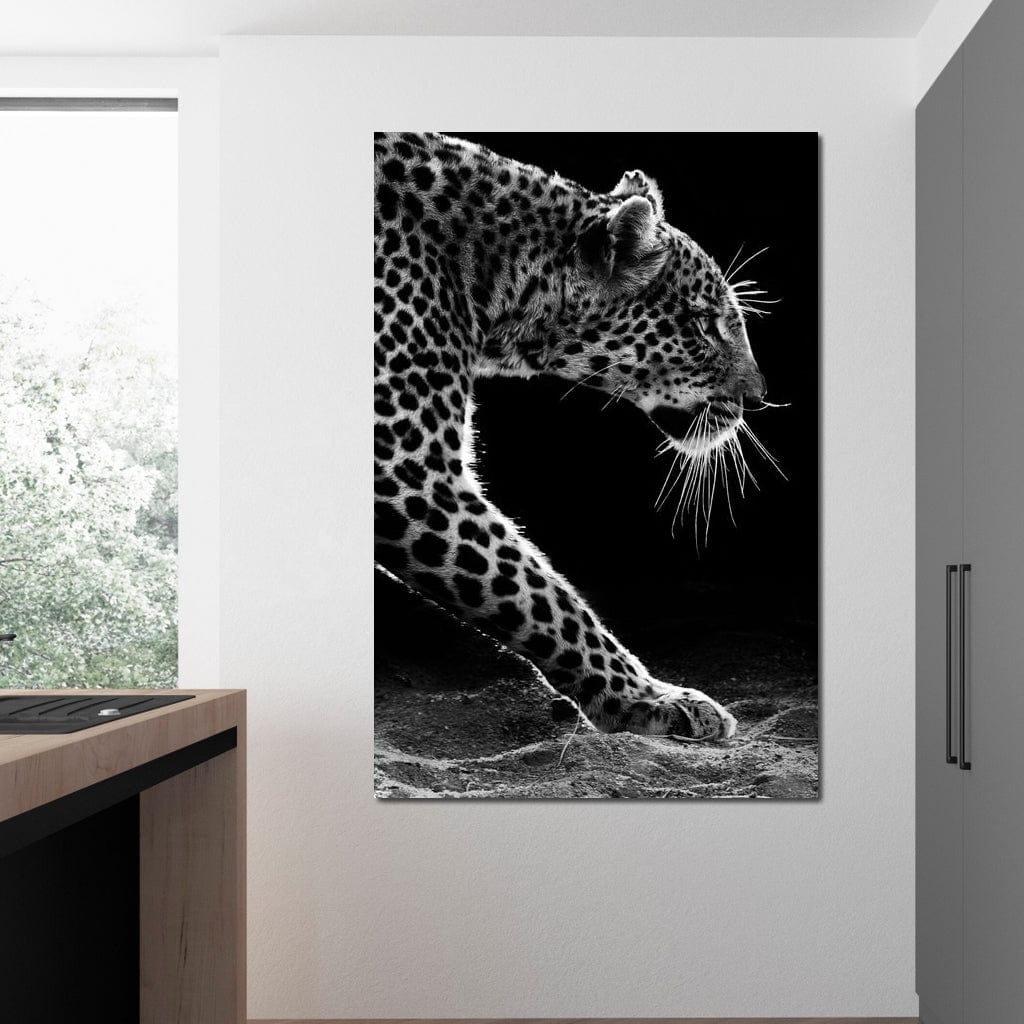 tablou canvas cu un leopard surprins in moment de atac, din profil, pe fundal intunecat alb si negru