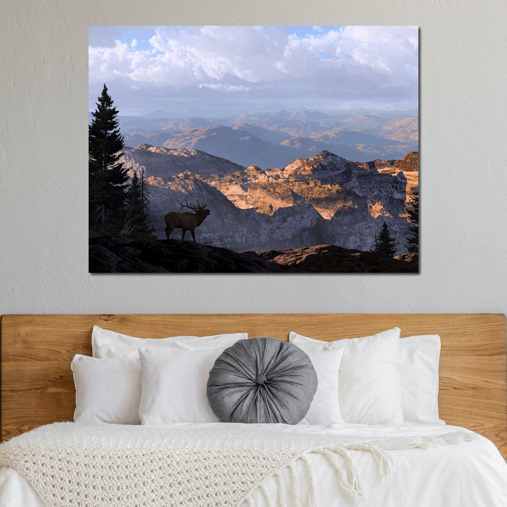 tablou canvas cu un elan intr-un peisaj montan, inconjurat de copaci si stanci sub cer senin