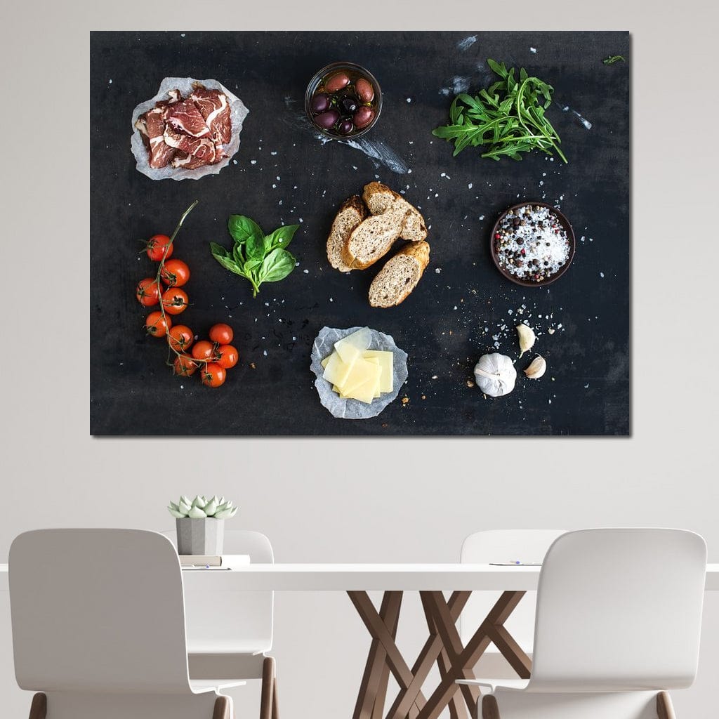 tablou canvas cu bruschette, rosii cherry, verdeturi, condimente si prosciutto pe o masa neagra