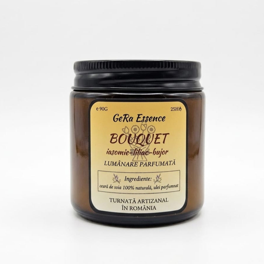 O lumânare de soia LuxCanva® realizată manual, GeRa Essence Bouquet, într-un borcan de sticlă maro, cu parfumuri florale de iasomie, liliac, bujor și hiacint. Fabricată în România din ceară 100% naturală. 90g, arde până la 25h.