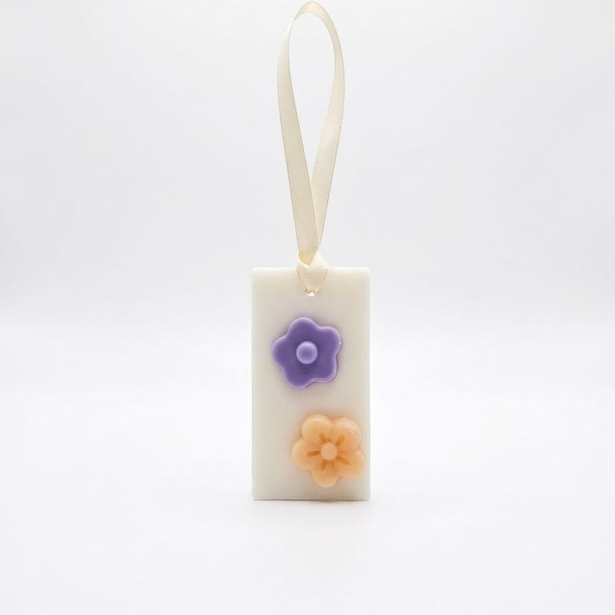 LuxCanva® Odorizant Dulap/Sertar/Pantofar, Buchet de esențe GeRa - Iasomie, Liliac, Bujor, Zambile este un săculeț din ceară albă de 30 g, realizat manual, cu decor floral și panglică crem, ideal pentru împrospătarea dulapurilor. Afișat pe un fundal alb simplu.